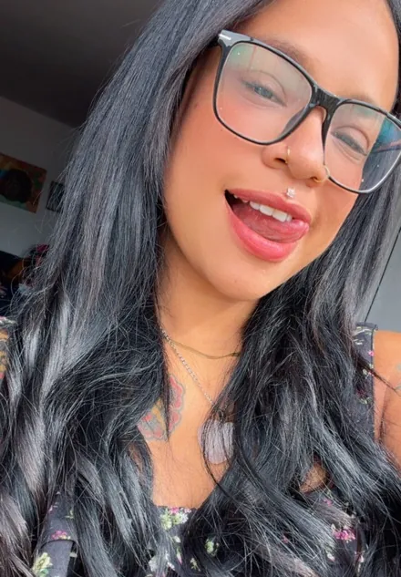 Adult woman with glasses smiling toward the camera