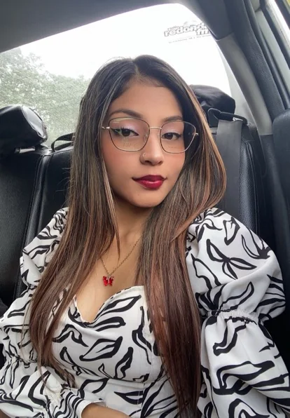 Adult woman with glasses seated in a car, editorial portrait